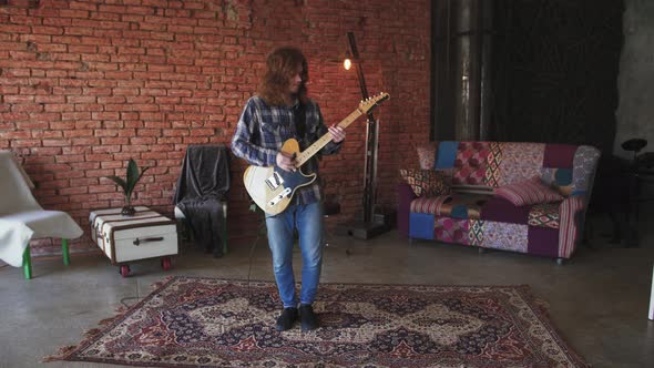 Portrait of Young Man Musician with Long Red Hair Playing Electric Guitar at Home Slow Motion