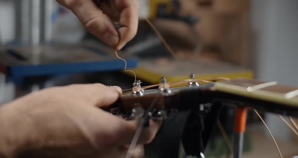 Guitar Tech Takes Off the Old Strings From the Guitar Tuners Changing the Strings on the Acoustic