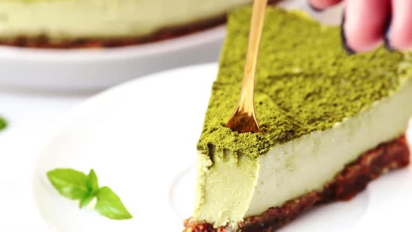 Slice of raw vegan matcha cake on white plate.