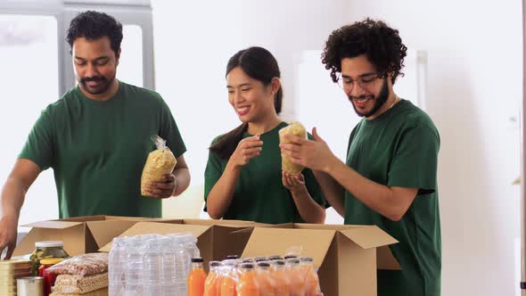 Happy Volunteers Packing Food in Donation Boxes