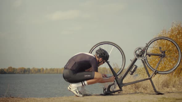 Cyclist Checking His Bike After Triathlon.Triathlete Fixes His Bicycle After Breakdown. Bike In Park