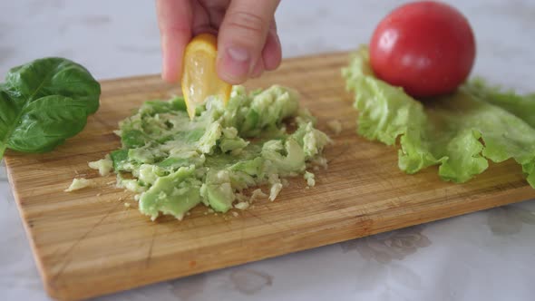 Squeezing Lemon on Mashed Avocado