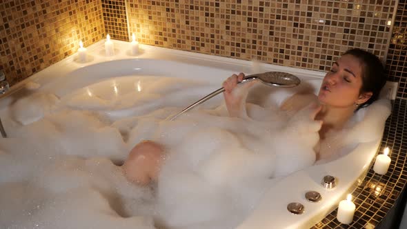 Young Woman Sings in a Bubble Bath By Candlelight