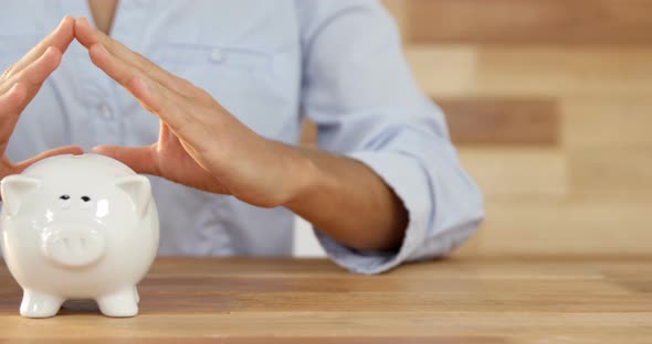 Woman gesturing on piggy bank