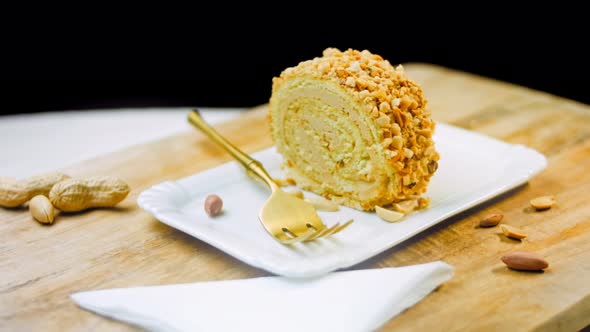 Peanut Roll Cake on a Plate with a Gold Fork