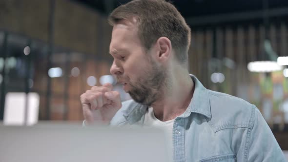 Close Up of Young Man Coughing at Work