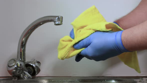 Male Hands in Gloves Closeup Wash and Dry a Lemon with a Towel