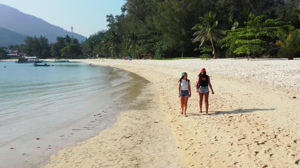 Ladies relaxing on perfect bay beach voyage by blue ocean and white sand background of Koh Phangan n