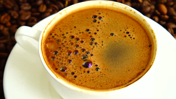 Cup with coffee on the background of coffee beans.