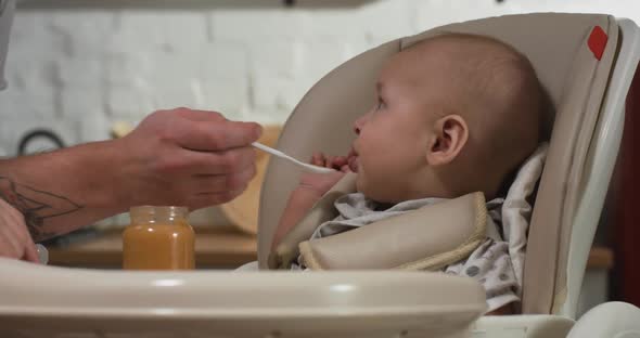 Mother Feeding Her Baby in Kitchen