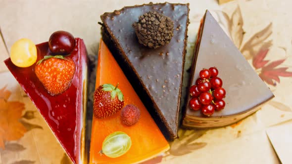 A Few Slices of White and Red Strawberry and Cherry Cake and Chocolate in an Open Box