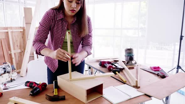 Woodwork and furniture making concept. Stylish craftswoman working in carpentry