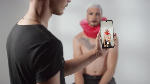 Man Taking Photo of Male Model with Theatrical Make-Up