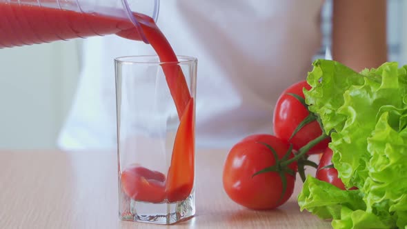 Tomato Juice Pouring From Jug Into a Glass.