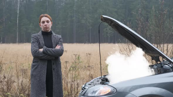 Sad Woman Standing on the Road By the Broken Car