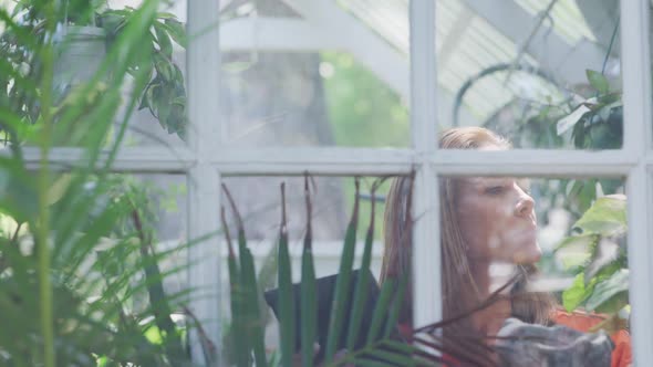 Woman gardening in a greenhouse