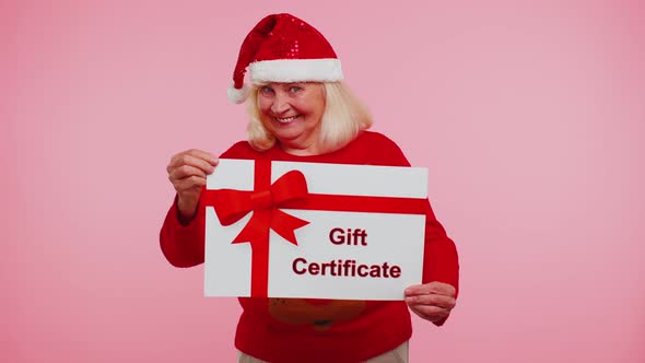 Elderly Grandmother Woman in New Year Sweater Presenting Card Gift Certificate Coupon Winner Voucher