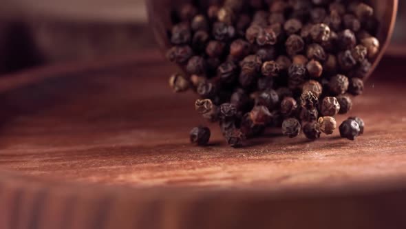 Black Pepper Falling on a Wooden Table