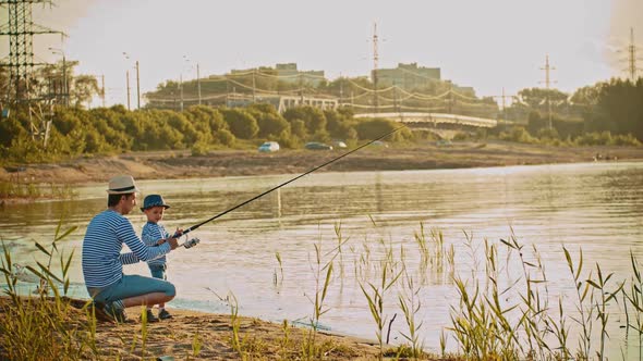 A Father and His Son on Fishing - Father Give His Son a Fishing Rod and Sit Near Him