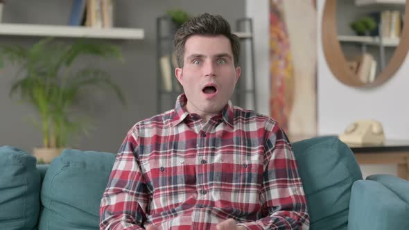 Portrait of Man Reacting to Failure While Sitting on Sofa