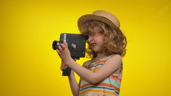 Girl Cinematographer in Straw Hat is Using Retro Camcorder in Yellow Background