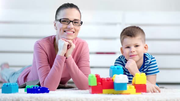 Young Charming European Mother Posing with Little Cute Son Smiling and Looking at Camera