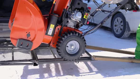 Young Man Removing Snow with Mechanical Snowplough