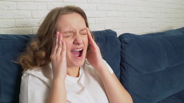 Young Woman Actively Massages the Temples of the Head Due to Headaches Migraines Spasms