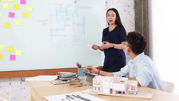 Asian  Interior Architect working with architectural model choosing material and study