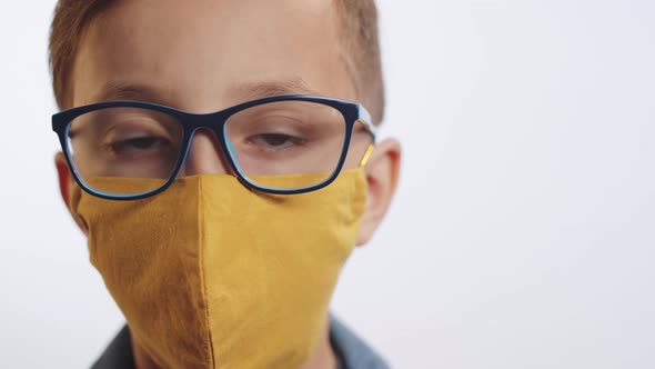 Little Boy in Face Mask Posing on White Background