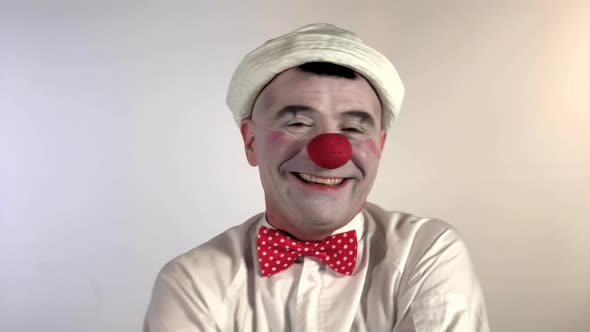 Emoji clown - Smiling and loudly crying face. A mime clown laughs but suddenly starts crying and str