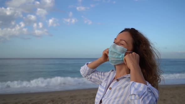 Happy woman wearing medical mask outdoor against blue sky background