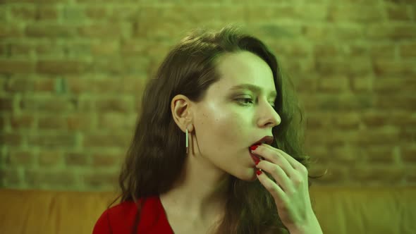 Close Up of Beautiful Young Woman Taking Lsd Pill Sitting on Couch in Nightclub