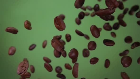 Roasted Arabica Coffee Beans Are Flying and Rotating on Olive Green Background