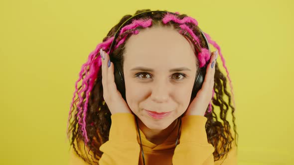 Young Woman in Headphones on Yellow Background