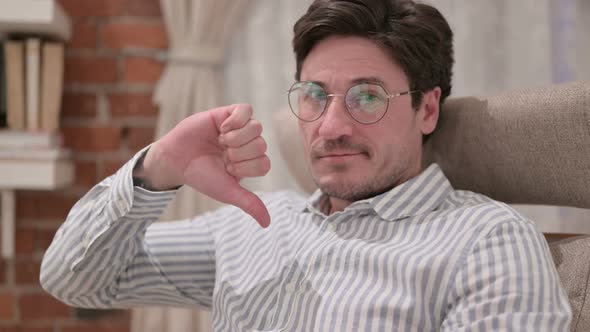 Portrait of Middle Aged Man showing Thumbs Down at Home