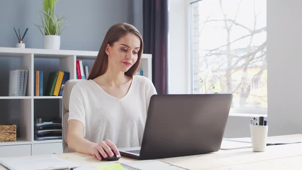 Young Woman Works at Home Office Using Computer.