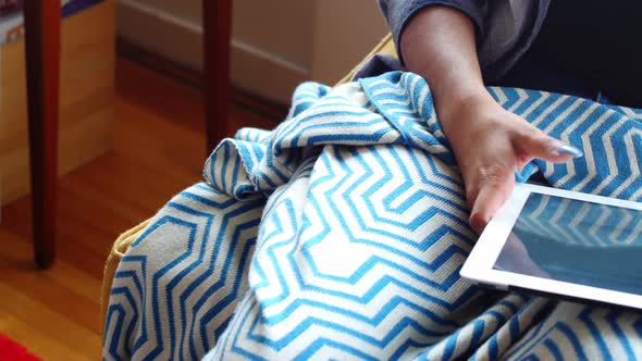 Beautiful woman using digital tablet in living room