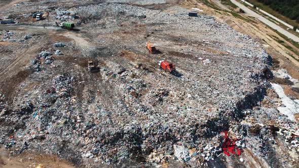 Aerial view of a garbage truck unloads a pile of garbage at a landfill.