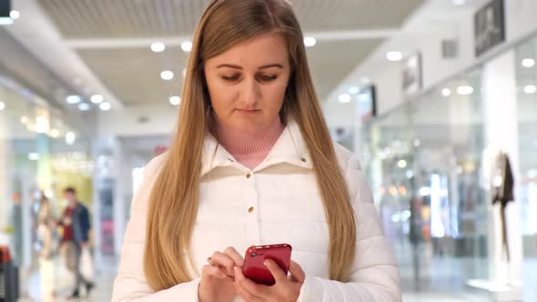 Attractive woman with a smartphone in her hands reads her messages on social networks