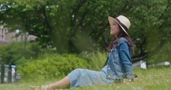 Woman sit on the grass and look around