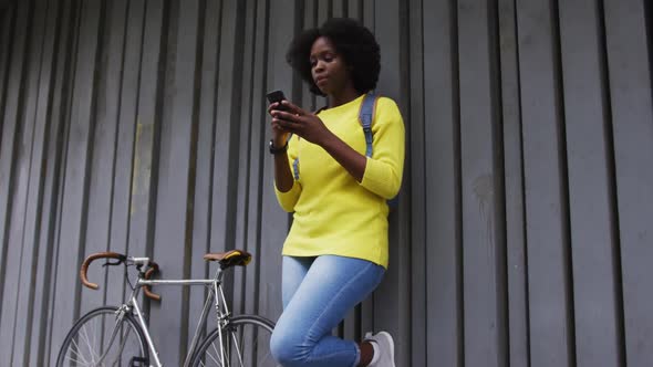 African american woman using smartphone in street