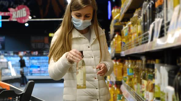 A Beautiful European Girl Takes Vegetable Oil in a Hypermarket