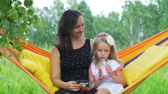 Mother Straighten Hair of Daughter in Hammock