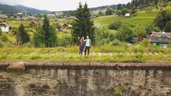 A couple walks along the old viaduct in the mountains Ukrainian Carpathians