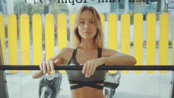 Beautiful Young Female in Sportswear Standing in the Gym and Looking at Camera