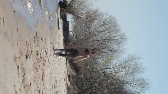 Young Woman Runs with Shih Tzu Dog Along Sea Sand Beach in Spring