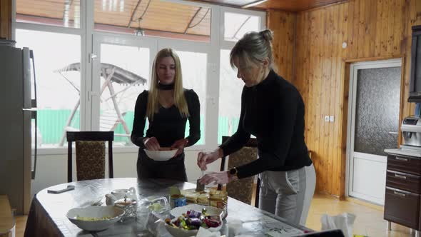 Mom and Adult Daughter are Preparing Dinner in the Kitchen