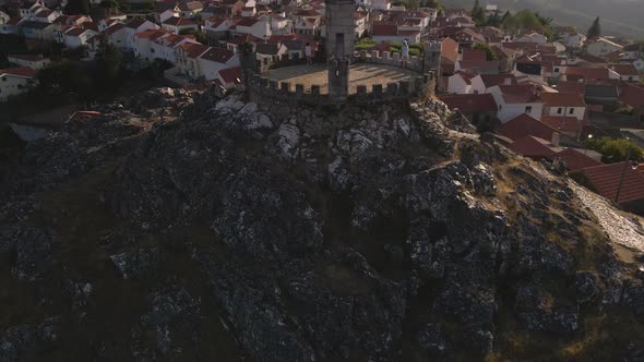 The medieval Folgosinho Castle comes into view with the white whiles of the town behind it.