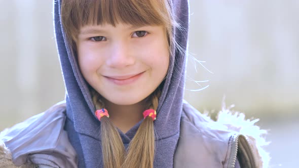 Portrait of happy child girl in warm clothes in autumn outdoors.